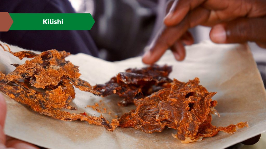 A close-up of Kilishi, a type of Nigerian street food made from thin strips of sun-dried meat