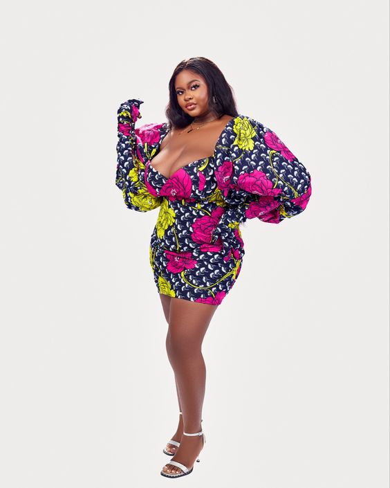 Ankara Gown Styles for Plus-Size Ladies in 2023: A chic model showcases an Ankara Gown with Gloves, featuring striking African prints, adding a touch of elegance to African fashion.
