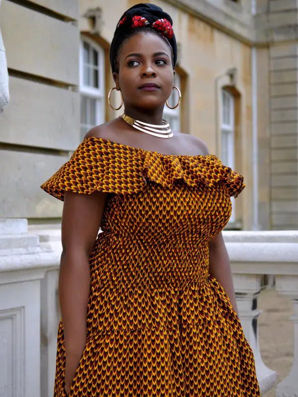 A confident model showcases The Bardot Ankara Gown with exquisite African prints, epitomizing the allure of African fashion.