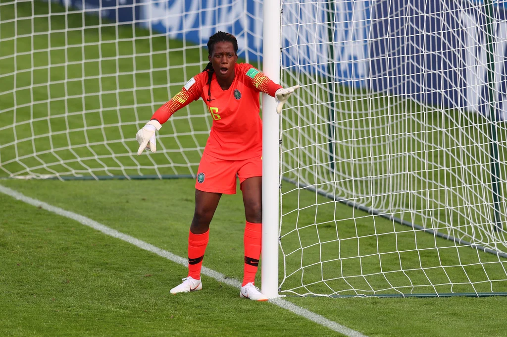 Chiamaka Nnadozie, a formidable Nigerian female footballer, demonstrating her exceptional goalkeeping skills while guarding the goal post during a crucial match.
