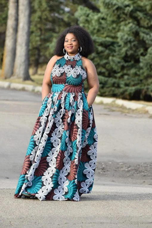A fashionable model dons The Halter Neck Ankara Gown adorned with intricate African patterns, showcasing the chic elegance of African fashion.