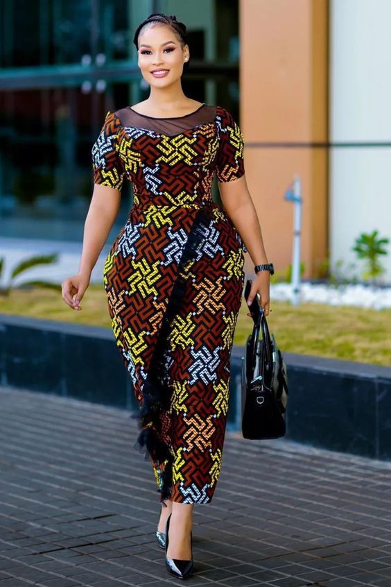 A stylish model effortlessly wears a Wraparound Ankara Gown with intricate African patterns, embodying the elegance of African fashion.