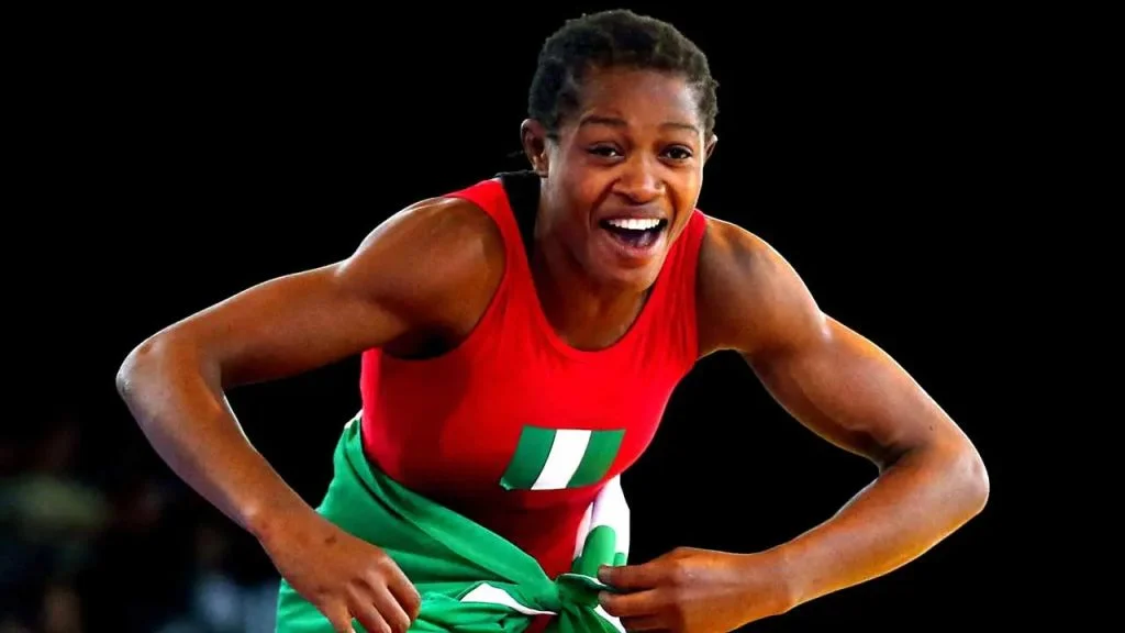 Odunayo Adekuoroye, renowned Nigerian female wrestler, displaying a flag after a victory